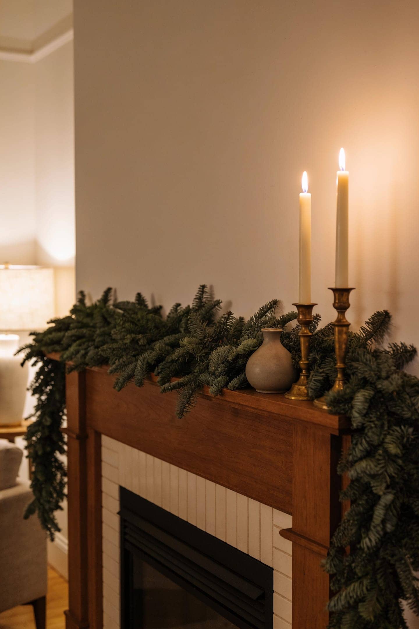 full faux pine christmas garland draped along a warm mantel