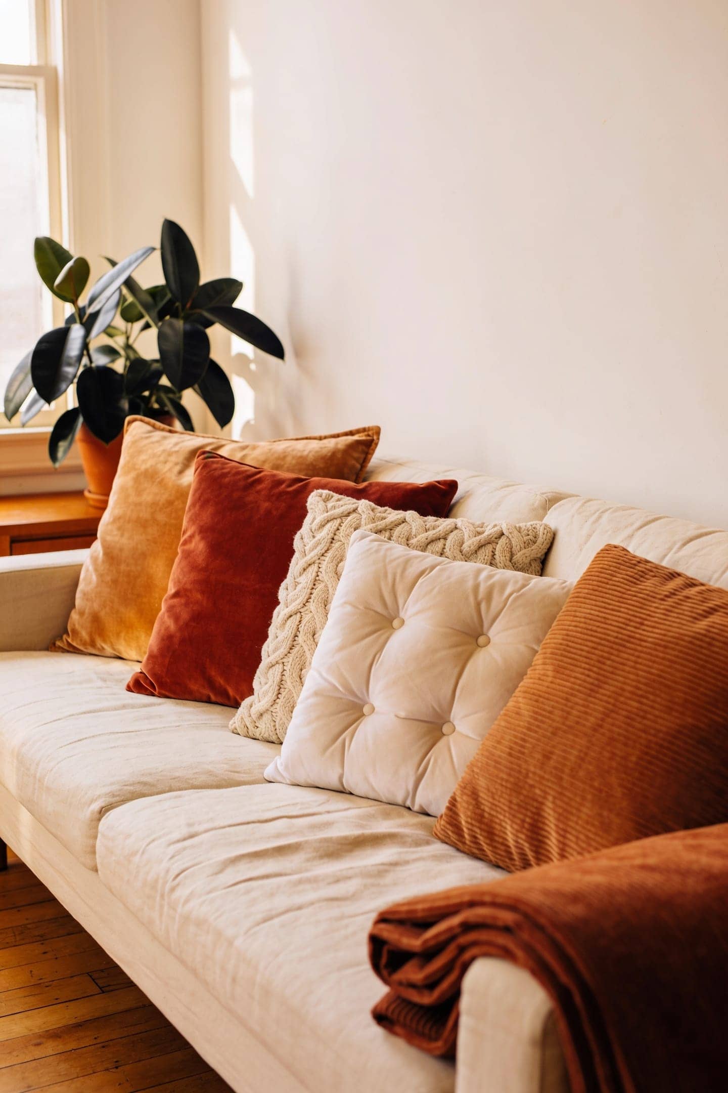 terracotta and cream throw pillows layered on a sofa